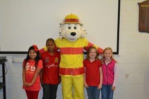 THE WINNERS. Students (from left) Jessica Mandoza, Nattryal Banks, Sara Hudson and Olivia Paszt flank Sparky at fire station 1 during the pizza party.