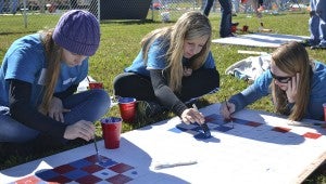 KEY PAINTERS: Kimberly Ange, Laura Whittington and Megan Elks, Southside High School Key Club members, painted checkerboard squares on table tops for Belhaven’s new playground.
