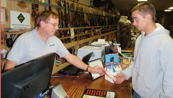 Richard Potter (L) from Warren’s Sport Headquarters in Washington shows prospective buyer Tyler Ayers a fishing lure that should make a good Christmas gift for a friend. Salespersons in sporting goods stores like this will do their best to help a prospective gift buyers choose the appropriate tackle for whatever type of fishing the person who’s going to receive the gift likes.