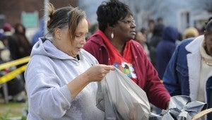 IN THE SPIRIT: Francina Lessy (foreground) and Doris Moore load up plastic bags with sweet potatoes at Dream Providers’ Christmas food donation.
