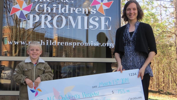CONTRIBUTED BACK AGAIN: Blake Wainwright (left) was back at UNC Children’s Hospital this year to make another donation. Helping Blake display the facsimile check is Kelly Partner, an event coordinator at The N.C. Children’s Promise, an organization that supports and raises funds for UNC Children's Hospital. 