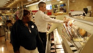 TONY BLACK | DAILY NEWS COLD CUTS: Reggie Beamon talks to deli employee Valerie Slade the day’s cold cuts. Beamon said he enjoys the interaction with his employees. 