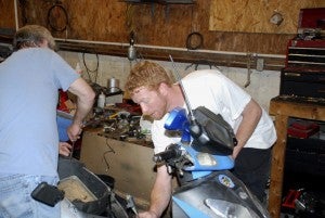 SCOOTERS: Mechanic Joe Ayers and shop owner Justin Wallace are inspecting a rebuilt motor in a customers scooter. 