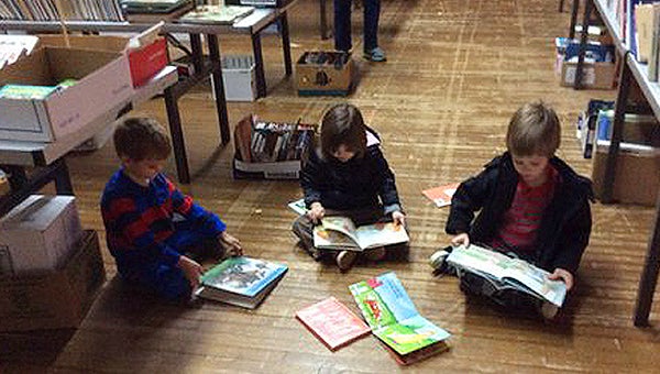 DIANE GRIFFIN LITERARY LAND:  Pictured left to right, Chandler Bradley, Gabrielle and David Winstead find a space to check out their finds at the recent Friends of Brown Library Book sale at the Washington Civic Center. 