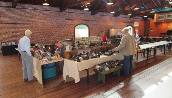 MIKE VOSS | DAILY NEWS PREPARING: Exhibitors and vendors for this weekend’s East Carolina Wildlife Arts Festival and North Carolina Decoy Carving Championships unpack items and set up their booths Friday morning. The festival, which opened Friday evening, continues through the weekend. 