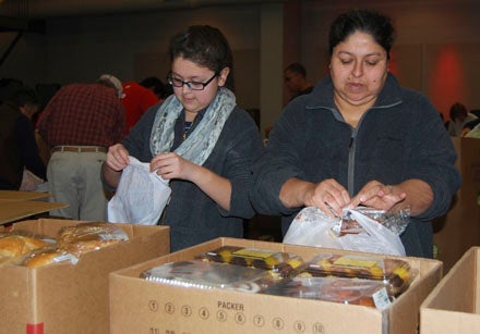 KEVIN SCOTT CUTLER | DAILY NEWS SIDE BY SIDE: Maria Benitez and her daughter, Kimberly, work side by side sorting and bagging food. 