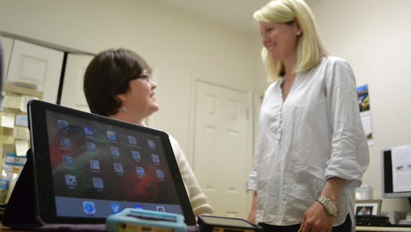 VAIL STEWART RUMLEY | DAILY NEWS STATE OF THE ART: Blind Center of North Carolina Director Blair Bergevin (right) and Kim Revels, a state social worker for the blind, discuss the center’s need for technology to assist clients. The center is having a drive to collect Apple products between two and four years old. 