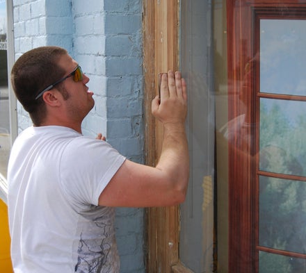 KEVIN SCOTT CUTLER | DAILY NEWS TIME TO WORK: Even work is made a bit more pleasant when the sun is shining and the mercury rises. Zachary Vaughn sands window trim on the storefront he is helping to restore on Market Street in Washington. 