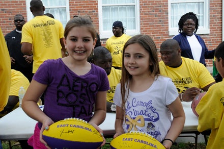 VAIL STEWART RUMLEY | DAILY NEWS (EAST) CAROLINA GIRLS: Sisters Jordan Dail, 11, and Logan Dail, 10, were thrilled to have footballs signed by former Baltimore Raven fullback Vonta Leach and Oakland Raiders’ defensive end C.J. Wilson (pictured behind the girls).  