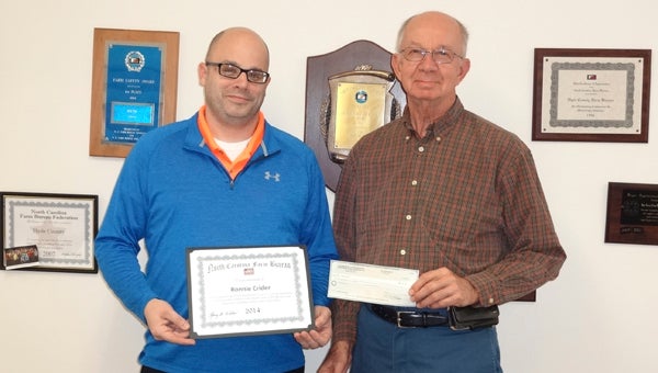 FARM BUREAU  AG OUTREACH: A Hyde County teacher recently received a grant to conduct agricultural-related projects for students. Pictured, Ronnie Crider, Mattamuskeet Early College High School biology teacher receives the grant from Glenn Spencer, President of the Hyde Co. Farm Bureau. 
