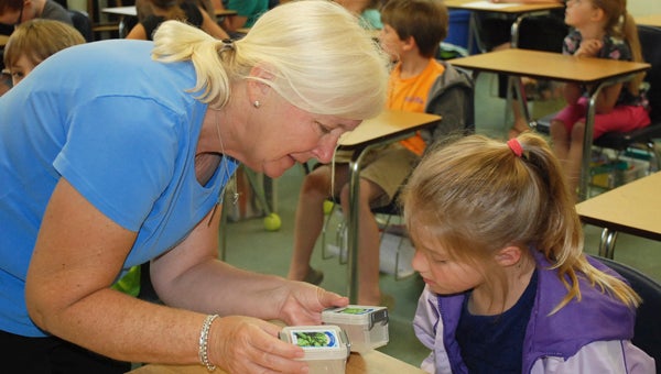 CAROLINE HUDSON | DAILY NEWS LIFE OF A SEED: Janis Deitrick shows some of the students an example of a germinating seed.