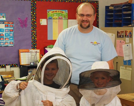 AMATEUR BEEKEEPERS: Colin Cahoon and Rylan Bowie try out beekeeping uniforms and equipment at Pungo Christian Academy’s Earth Day celebration.