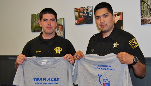 KEVIN SCOTT CUTLER | DAILY NEWS IN MEMORY: Capt. Jeremy Hewitt (left) and Deputy Javier Meza show off Team Alex shirts honoring the late Alejandro Zapata, a BCSO detention officer who died of cancer in 2012. Team Alex members will be involved in tonight's Relay for Life activities on the Washington waterfront.