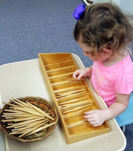 NEW AND OLD METHODS: A Montessori preschool student works with wooden spindles, a longtime method for learning how to count. (Sarah Gruninger)